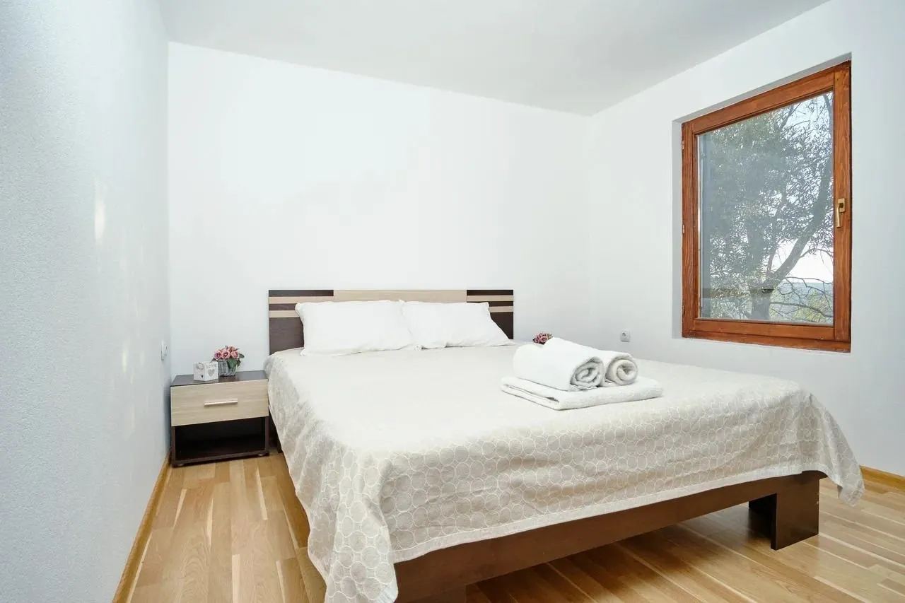 Bright and tidy bedroom with a double bed and wooden flooring.