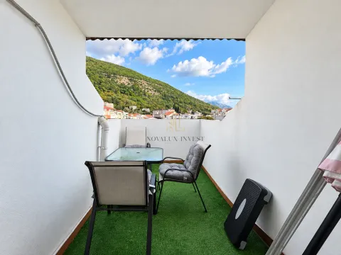 Namtještena terasa sa stolom, stolicama i vještačkom travom i pogledom na brdo. - image 9