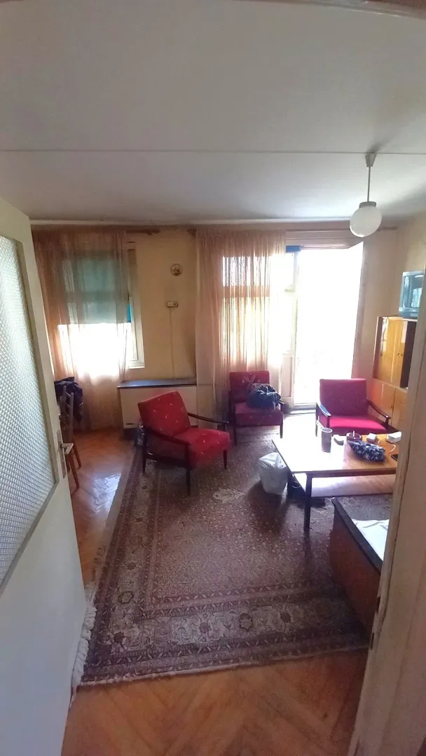 Dnevna soba sa tepihom, foteljama i izlazom na terasu.