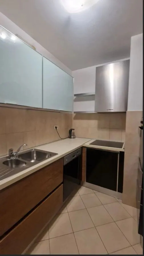 A functional kitchen with wooden lower cabinets and built-in appliances.
