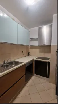 A functional kitchen with wooden lower cabinets and built-in appliances. - image 6