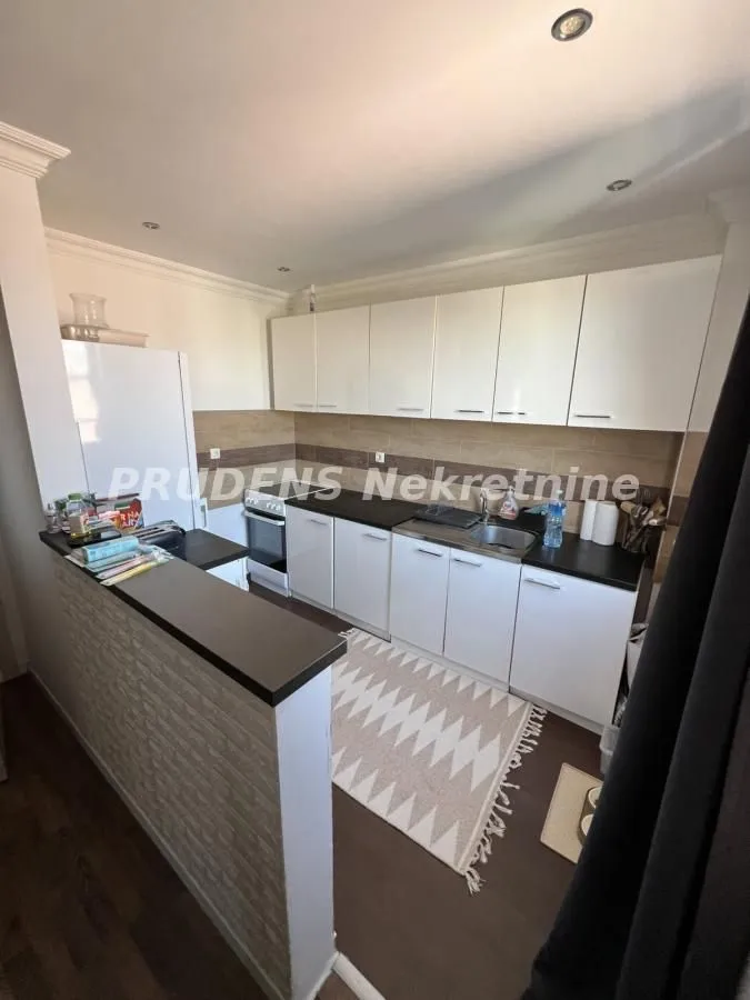 Small kitchen with white cabinets, dark countertop, and a breakfast bar.