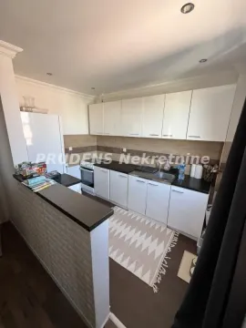 Small kitchen with white cabinets, dark countertop, and a breakfast bar. - image 2