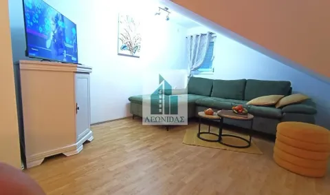 Living room with a green corner sofa and a television. - image 6