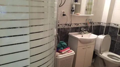 Bathroom with a shower cabin, sink, and toilet. - image 24