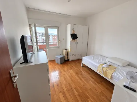 Namještena spavaća soba sa krevetom, garderoberom, televizorom i izlazom na terasu. - image 6