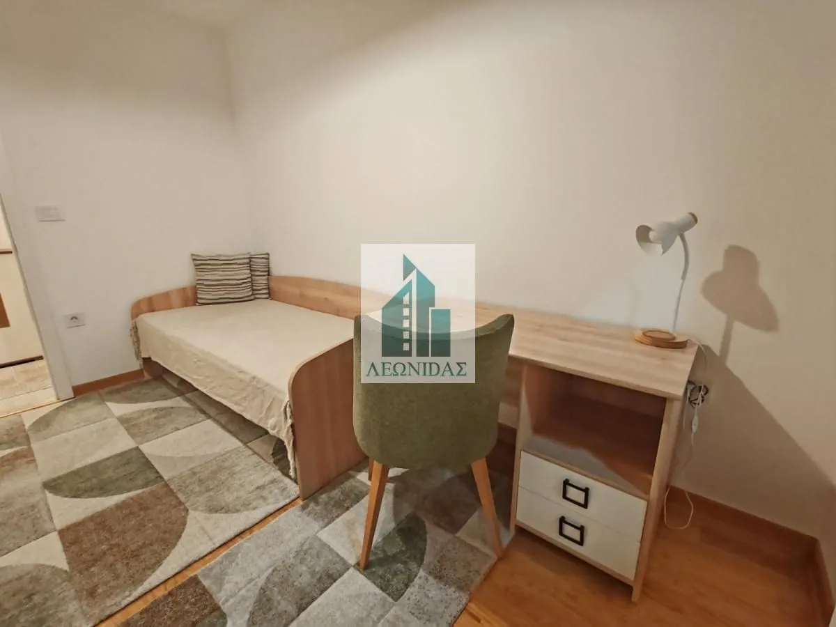 Small bedroom with a bed, a desk, and a rug.