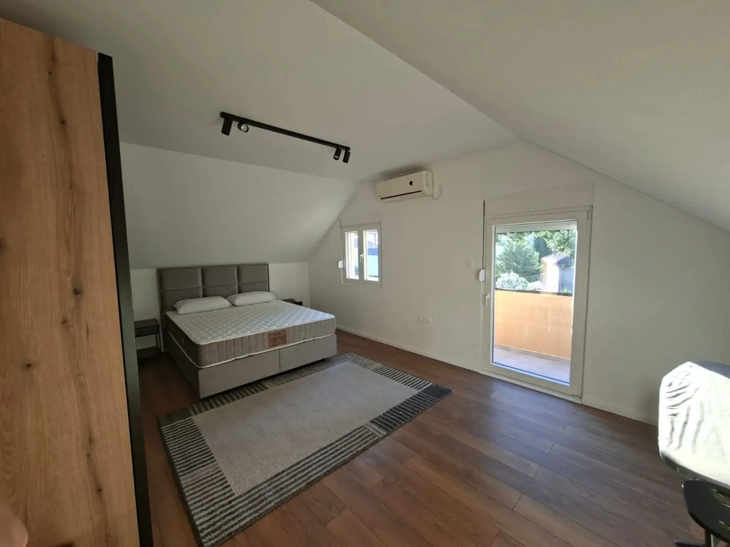 Attic bedroom with a double bed, wardrobe, and access to the terrace.
