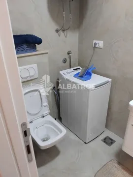 Bathroom with a toilet and a washing machine. - image 8