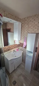 Small bathroom with a sink, mirror, and white cabinetry. - image 8