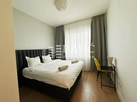 Furnished bedroom with a double bed, desk, and window with curtains. - image 10