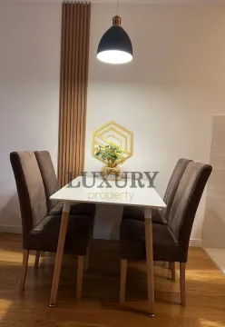 Dining area with a table and four upholstered chairs. - image 2
