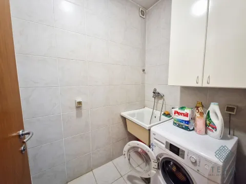 Bathroom with a washing machine, sink, and wall cabinet. - image 4