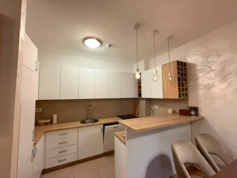 Moderna kuhinja sa bijelim elementima i šankom. - image 13