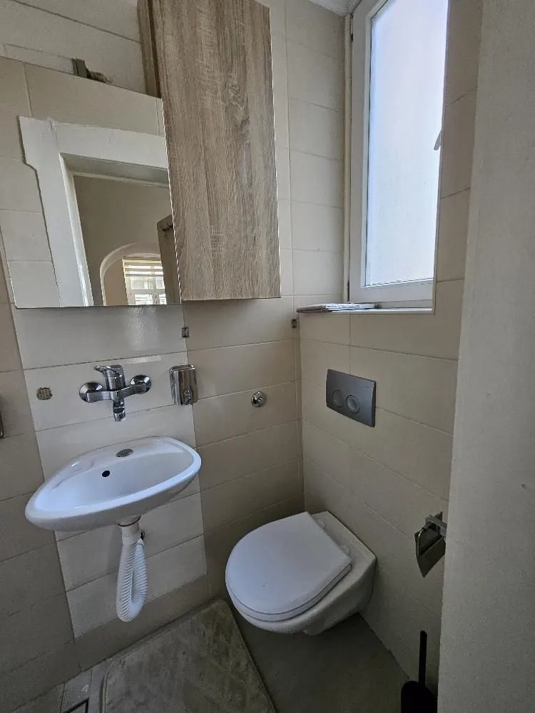 Manje kupatilo sa lavaboom, wc šoljom i zidnim elementom.