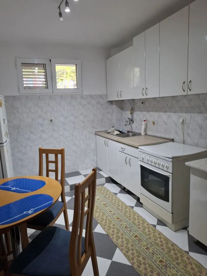 Smaller kitchen with a dining table and white cabinetry.