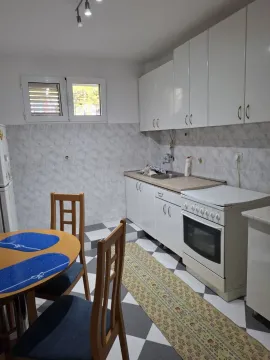 Smaller kitchen with a dining table and white cabinetry. - image 3