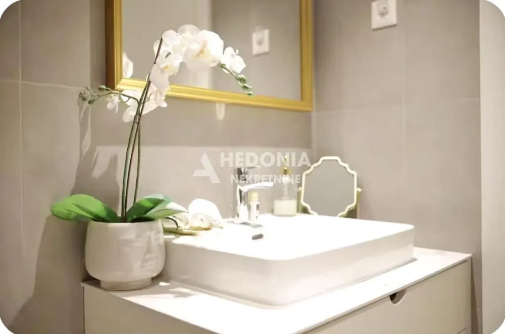 View of the washbasin and mirror in a furnished bathroom.