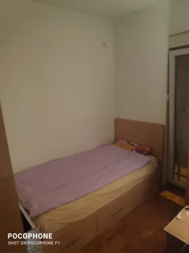 A small bedroom with a single bed and wooden flooring. - image 4