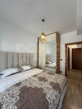 Furnished bedroom with a double bed, wardrobe, and a pendant light. - image 5