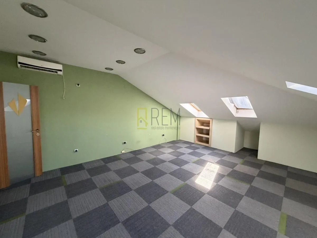 Attic room with sloping ceiling and roof windows.