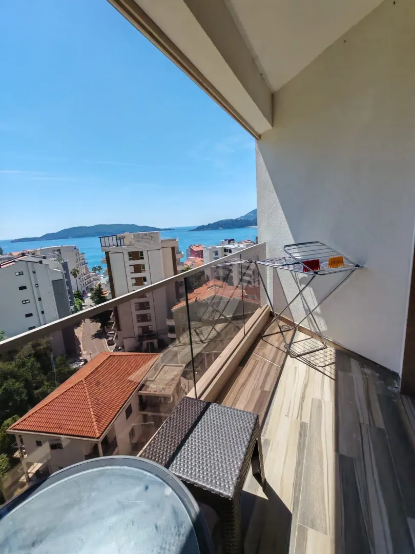 Balcony with a view of the sea and surrounding buildings.