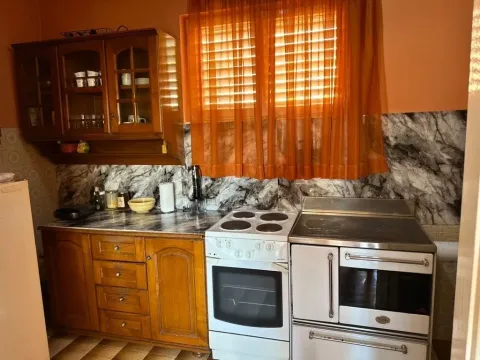 Starija kuhinja sa drvenim elementima i šporetom. - image 7