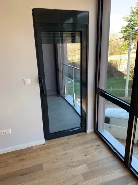 Interior view towards the balcony with a glass railing and large glass surfaces. - image 7