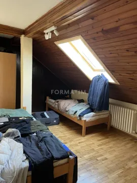 Attic bedroom with wooden ceiling and beds. - image 11