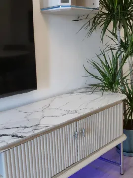 Detalj enterijera sa komodom i televizorom na zidu u dnevnoj sobi. - image 4