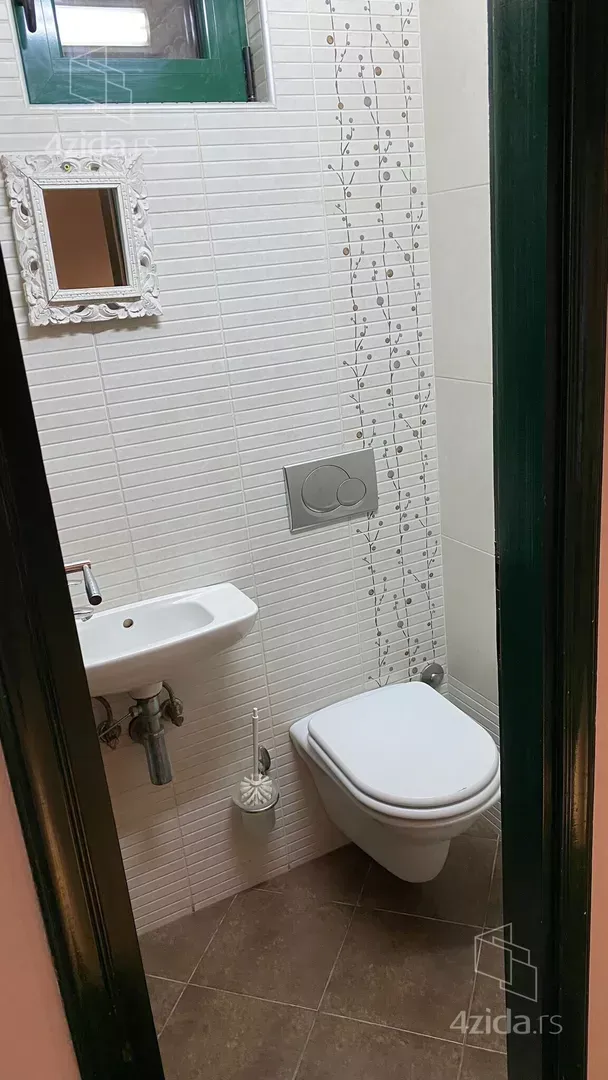 Small bathroom with a sink, toilet, and mirror.