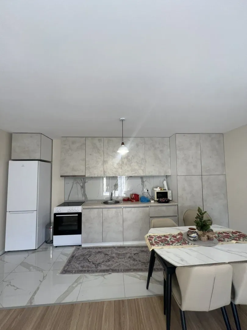 Bright kitchen with a dining table and grey cabinets.