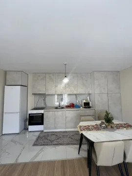 Bright kitchen with a dining table and grey cabinets. - image 14