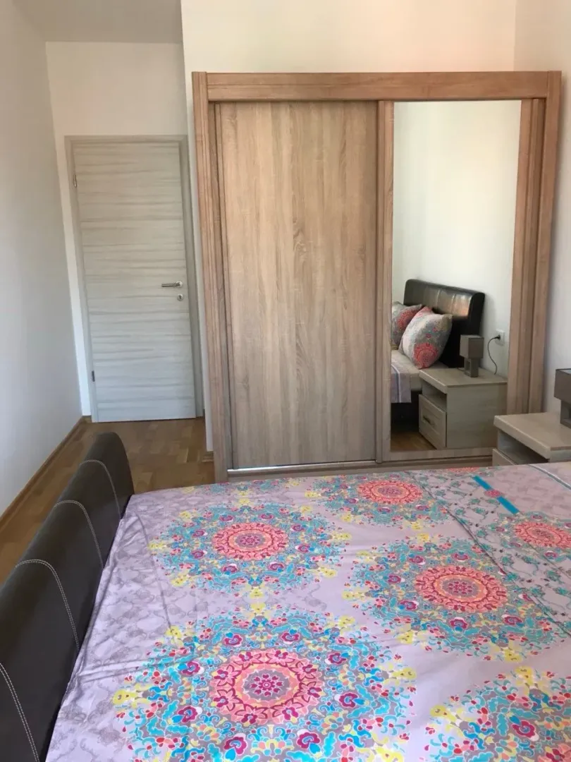 Namještena spavaća soba sa velikim garderoberom i bračnim krevetom.
