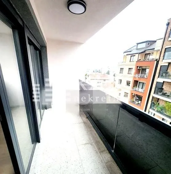 Spacious balcony with a view of surrounding buildings.