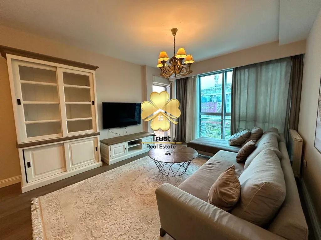 Spacious living room with a sofa set, large cabinet, and access to the terrace.