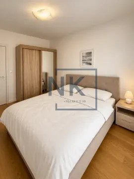 Furnished bedroom with a double bed, wooden wardrobe, and nightstand. - image 3