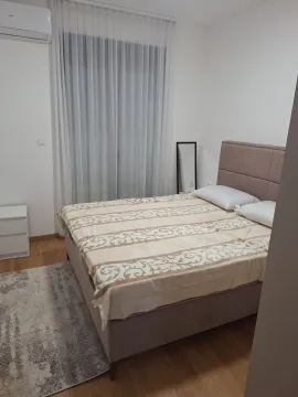 Furnished bedroom with a double bed and a window covered with curtains. - image 6