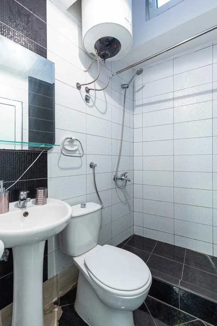Manje kupatilo sa tuš kabinom, umivaonikom i wc šoljom.