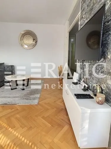 Living room with TV, console, and furniture.