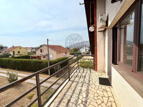 Prostrana popločana terasa sa metalnom ogradom i pogledom na okolno naselje. - image 11