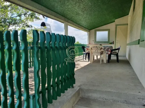Natkrivena terasa sa stolom za ručavanje i zelenom ogradom. - image 18
