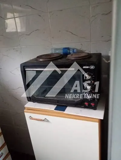 Small electric stove with an oven on a kitchen cabinet.