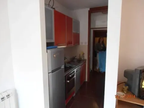Manja kuhinja sa crvenim elementima i pogledom na hodnik. - image 7