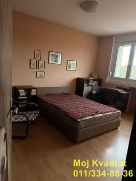 Nameštena spavaća soba sa bračnim krevetom i slikama na zidu. - image 7