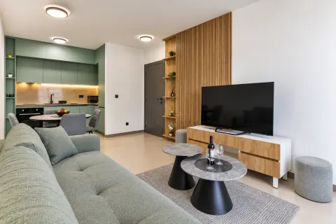Living room with sofa, television, and dining area in the background. - image 3