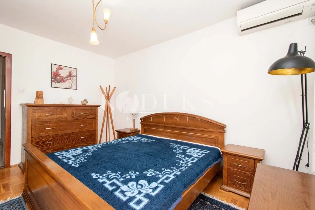 Bedroom with a wooden bed, chest of drawers, and a nightstand.