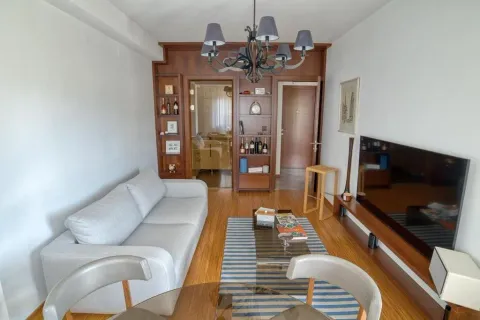 Living room with a sofa, dining table, and TV. - image 15