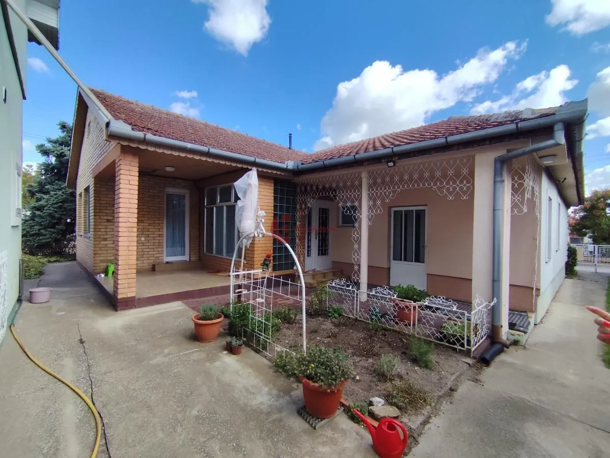 View of the courtyard and facade of the family house with a covered terrace.
