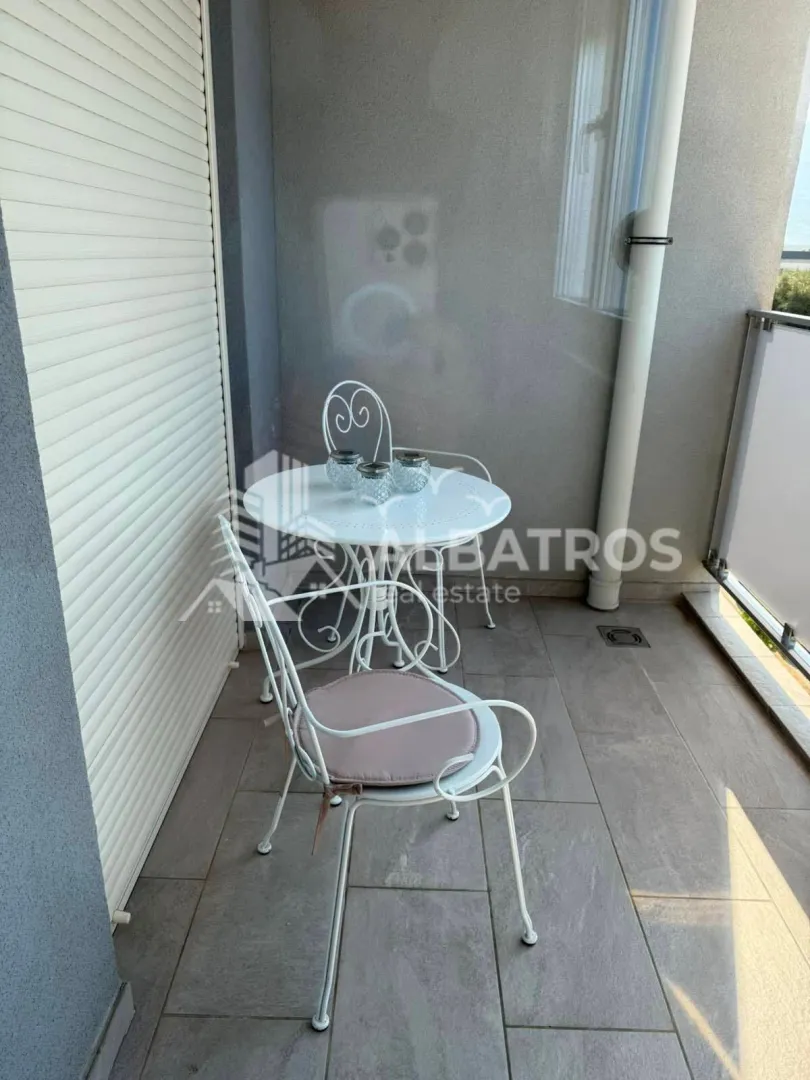 Manji natkriveni balkon sa garniturom za sjedenje.